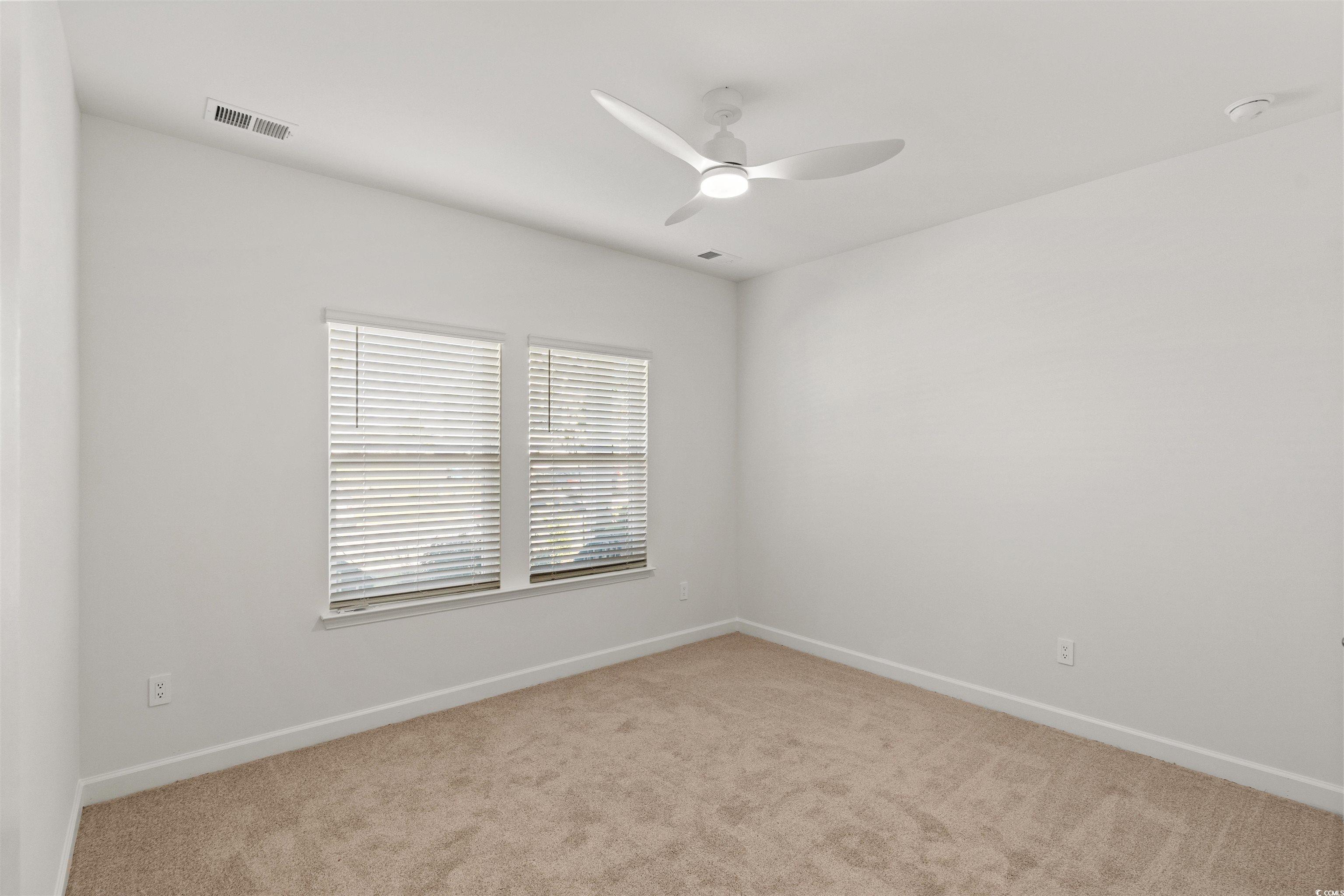 1546 Regal Fern Way Longs, SC 29568 - Photo 19 of 34 Empty room with light carpet and ceiling fan