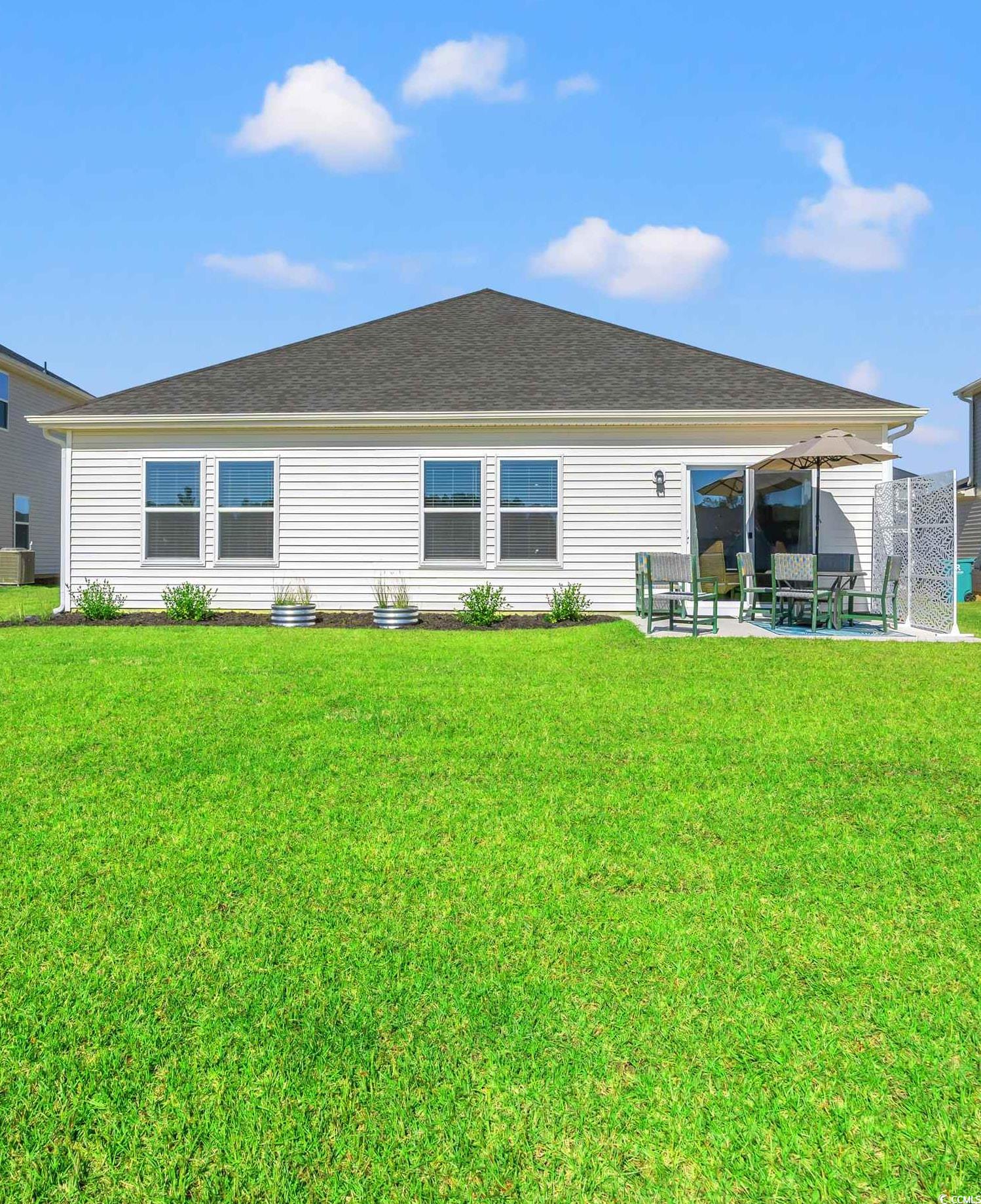 1546 Regal Fern Way Longs, SC 29568 - Photo 25 of 34 Back of property with a lawn and a patio