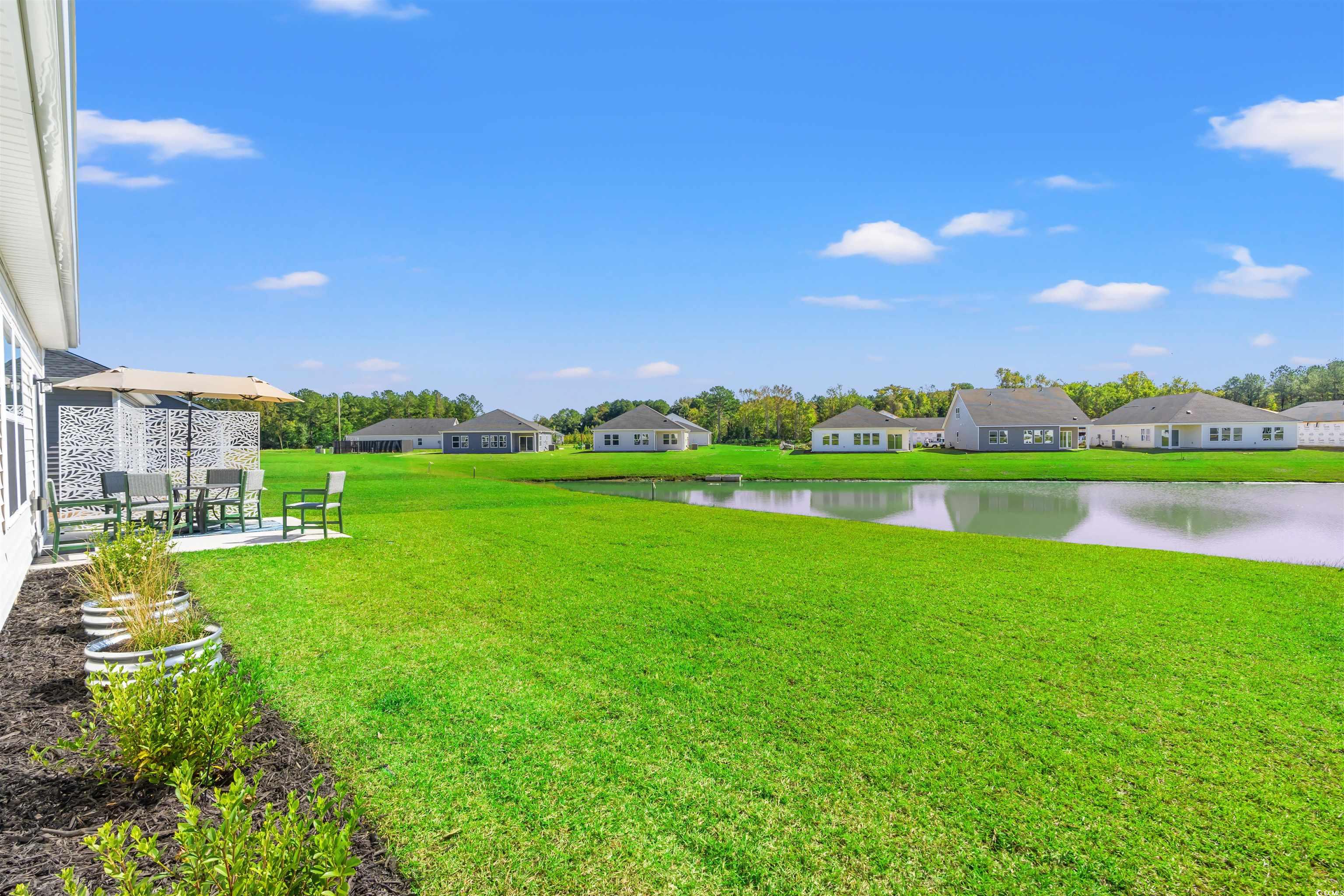 1546 Regal Fern Way Longs, SC 29568 - Photo 26 of 34 View of green lawn with a water view, a patio, and a residential view