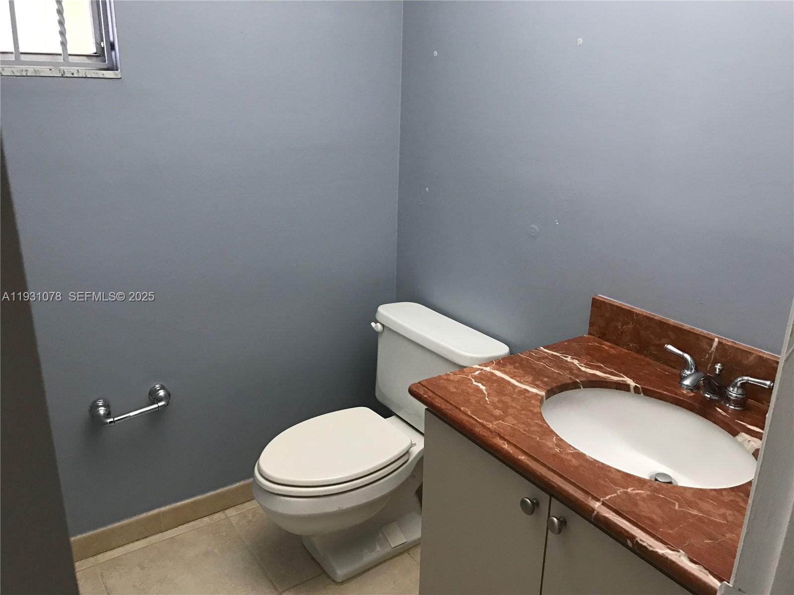 100 Northwest 87th Avenue, Unit E102 Miami, FL 33172 - Photo 11 of 17 a bathroom with a granite countertop toilet sink and mirror