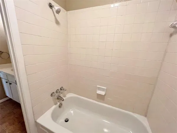 a bathroom with a white sink a shower and a window