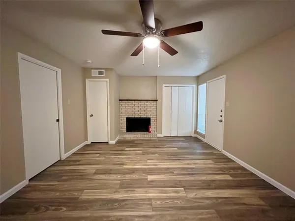 a view of an empty room with window and fireplace