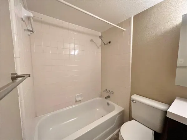 a white toilet sitting next to a bath tub