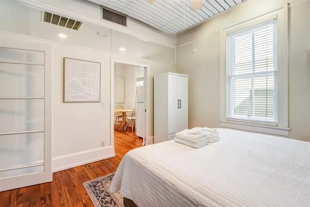 a bedroom with a bed and wooden floor