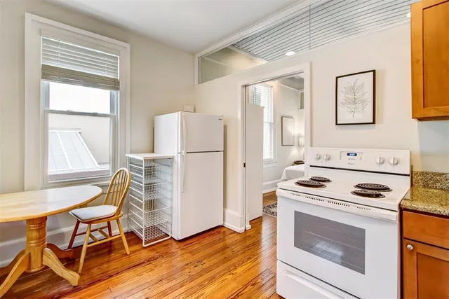 a kitchen with a stove a refrigerator and a table