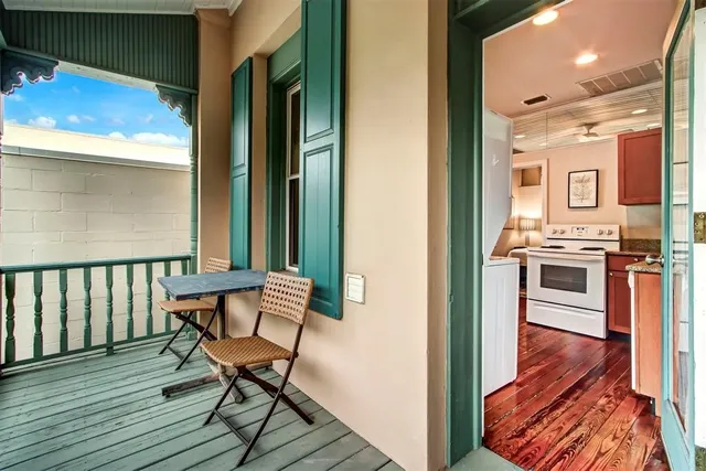 a view of a hallway with wooden floor and seating space