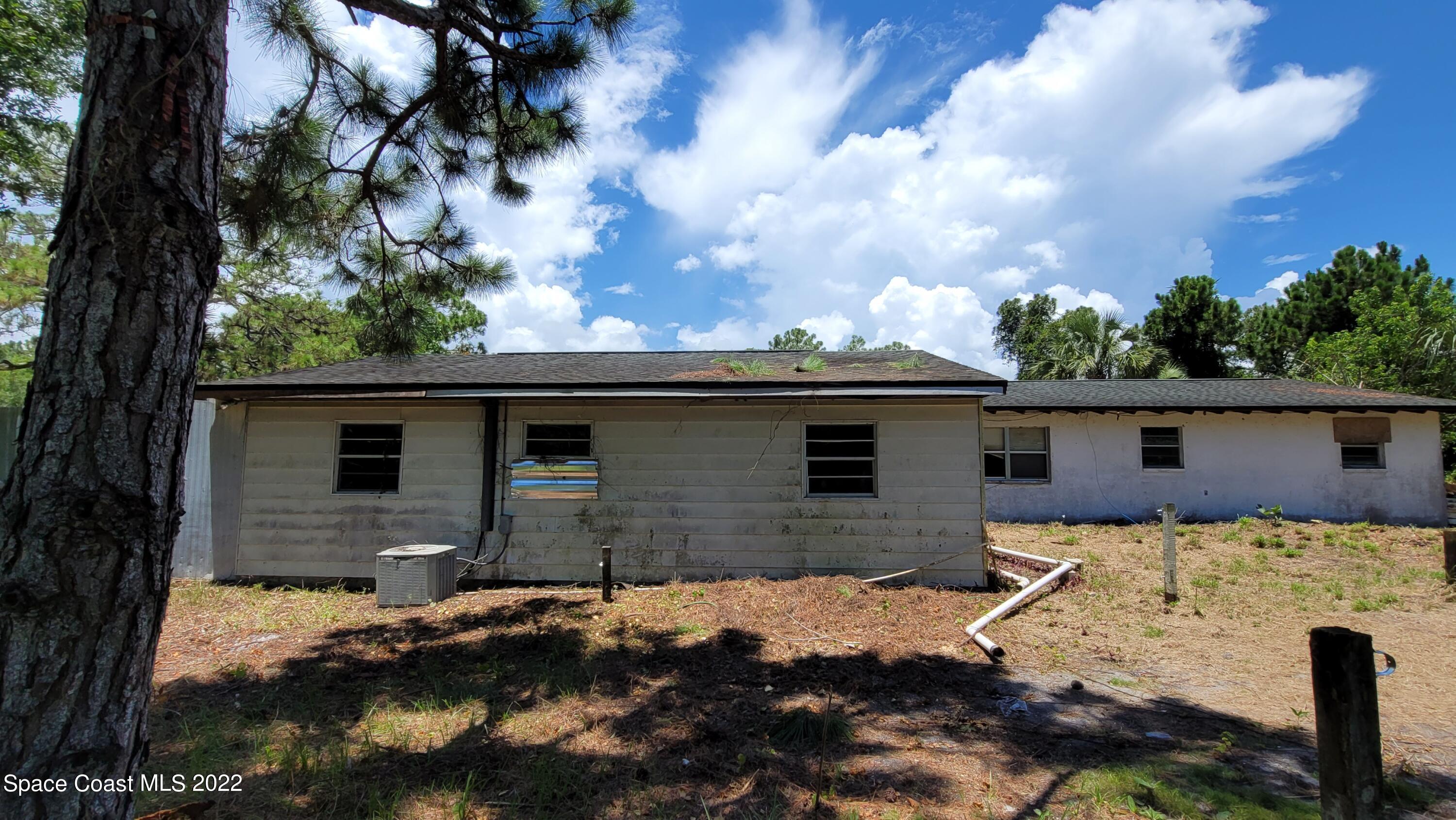 1910 Atz Road Malabar, FL 32950 - Photo 13 of 58 a backyard of a house with dishwasher and wooden fence