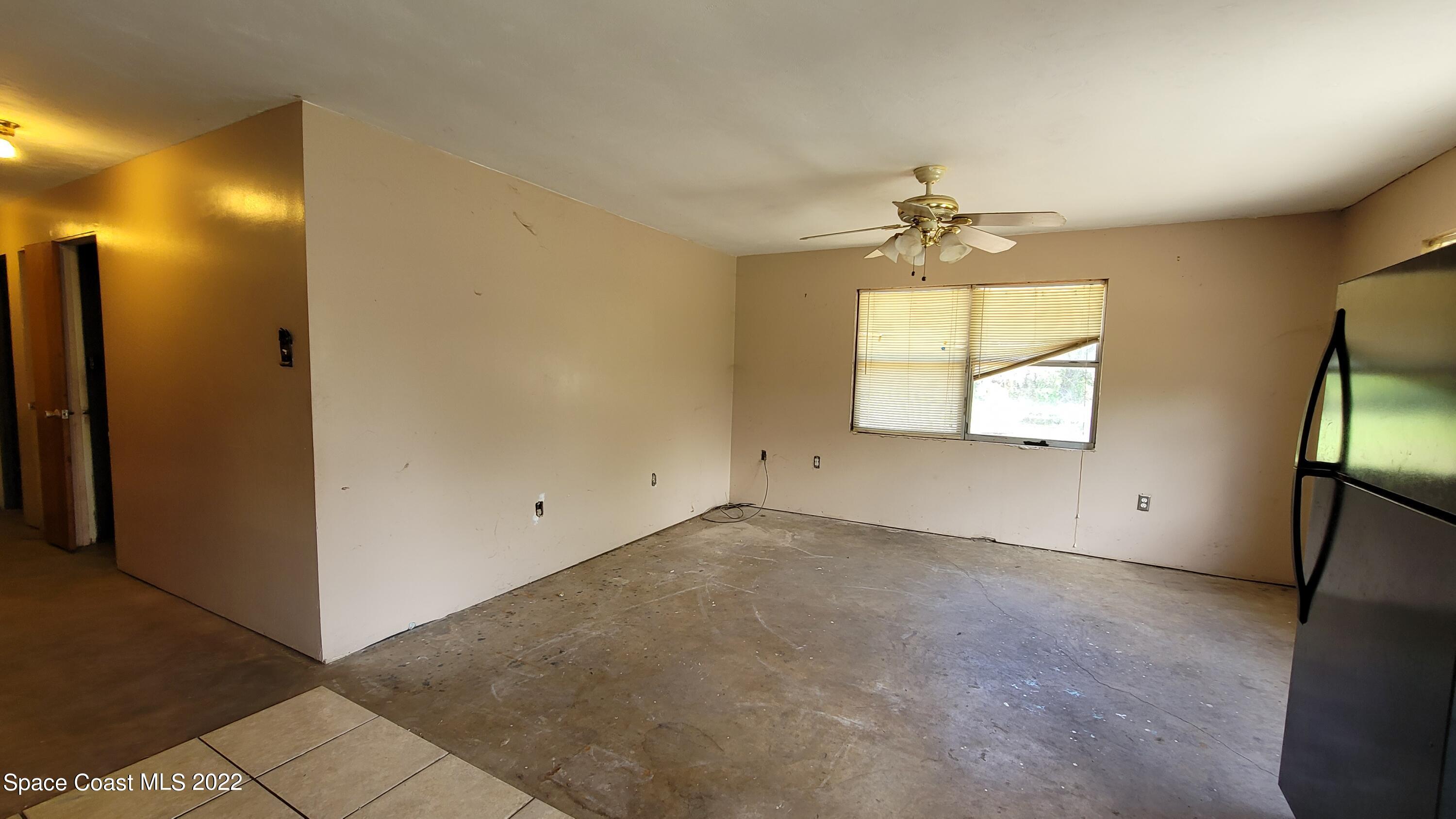 1910 Atz Road Malabar, FL 32950 - Photo 18 of 58 an empty room with windows and a chandelier fan