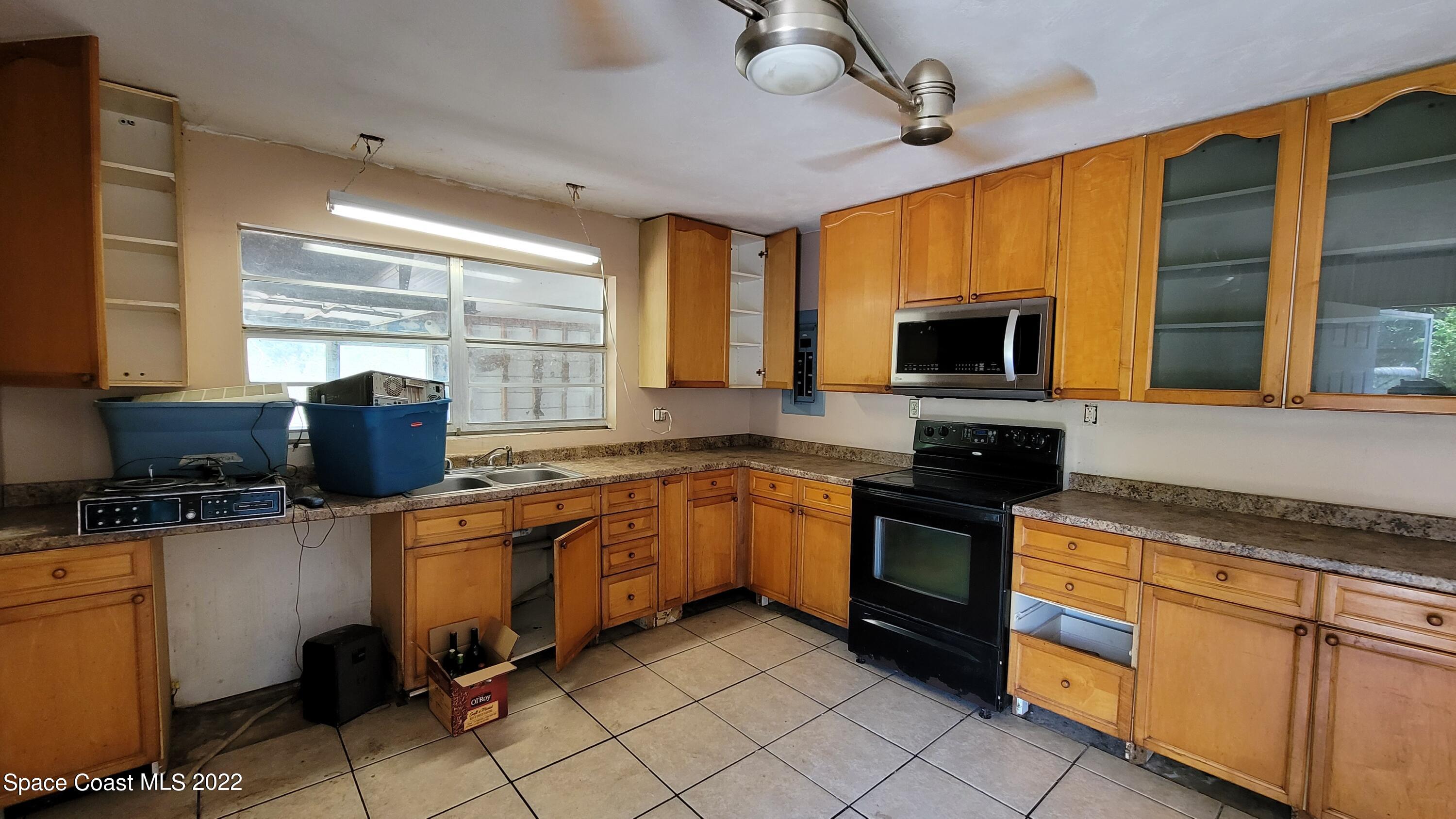 1910 Atz Road Malabar, FL 32950 - Photo 21 of 58 a kitchen with stainless steel appliances granite countertop a stove sink microwave and refrigerator