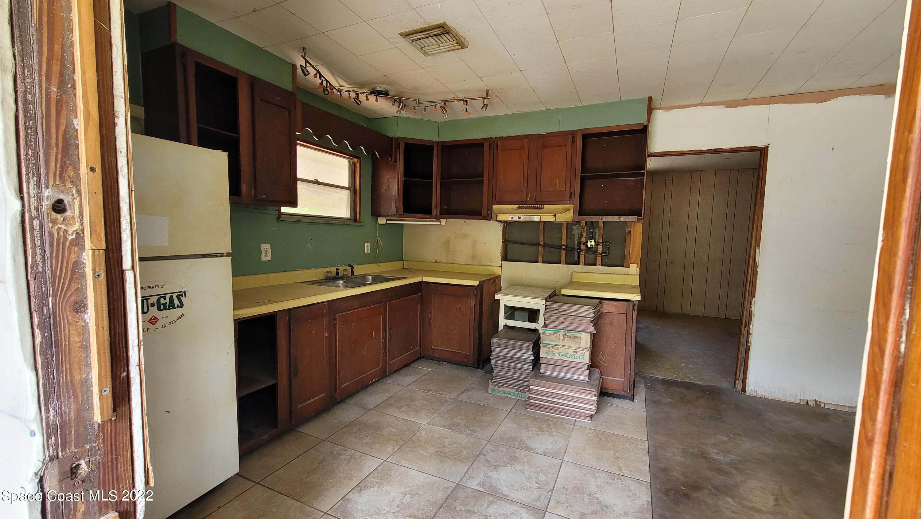1910 Atz Road Malabar, FL 32950 - Photo 39 of 58 a kitchen with a refrigerator and a sink
