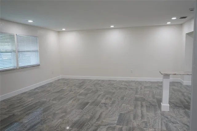 an empty room with wooden floor and window