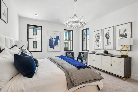a spacious bedroom with a large bed and a chandelier