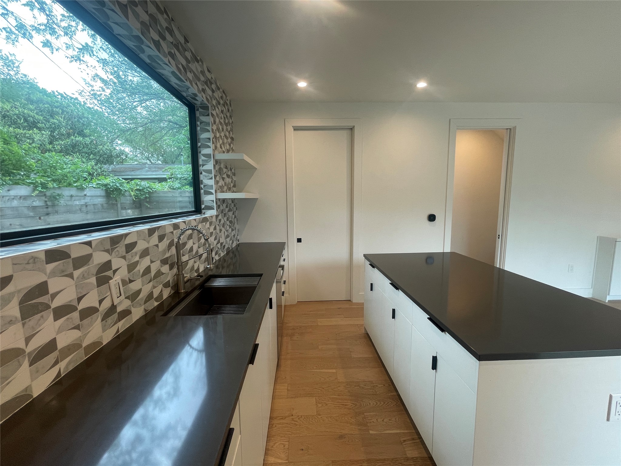 4604 South 2nd Street, Unit 2 Austin, TX 78745 - Photo 12 of 35 Expansive island and quartz countertops galore! Door at back of photo is a butler pantry, with the refrigerator.