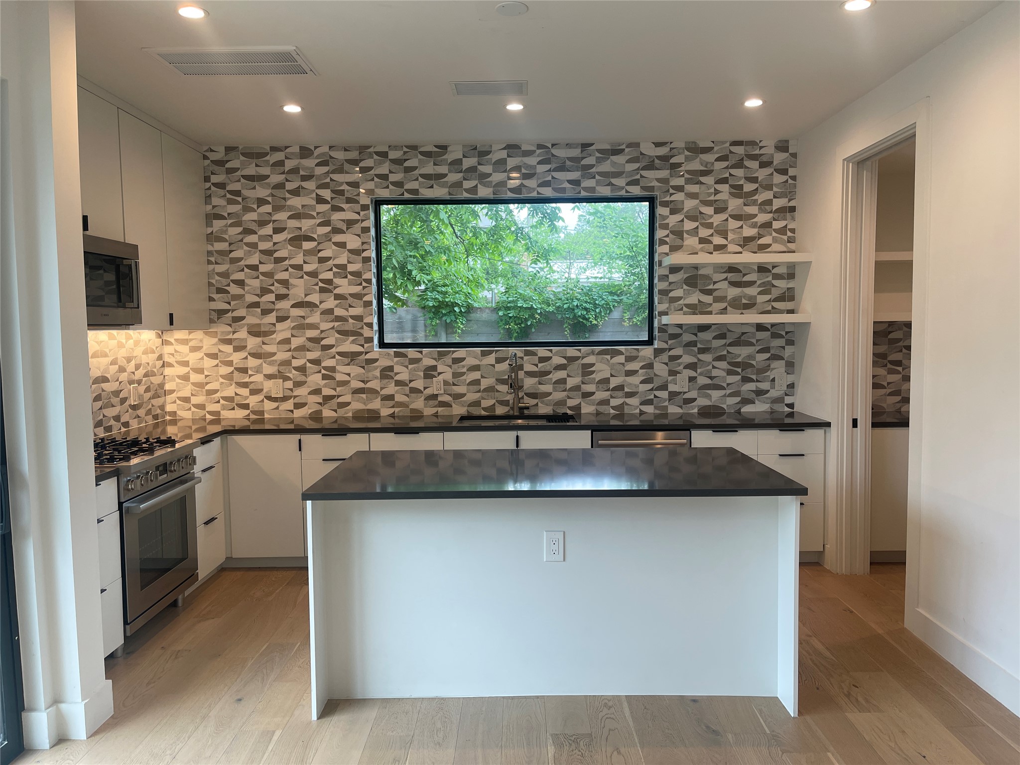 4604 South 2nd Street, Unit 2 Austin, TX 78745 - Photo 7 of 35 This modern kitchen allows the chef to enjoy the party. Expansive island accommodates 4 barstools. Butler's pantry with fridge at back right.