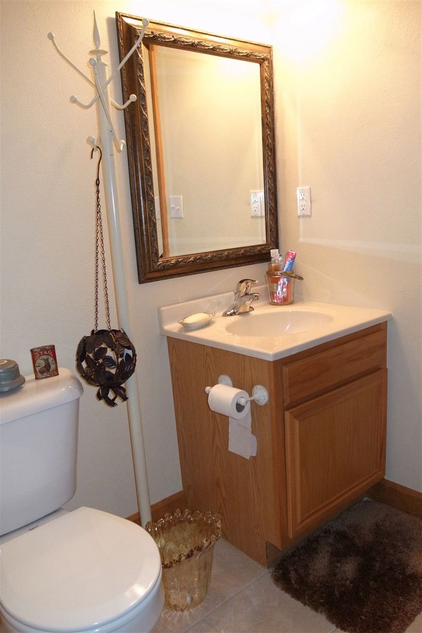 10192 Metalmark Lane, Unit 4 Roscoe, IL 61073 - Photo 10 of 16 a bathroom with a sink a toilet a mirror and bathtub