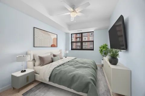 a bedroom with a bed mirror and window