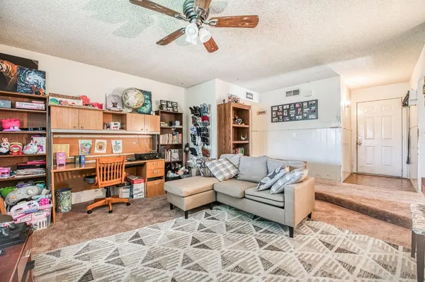 a living room with furniture and a book shelf