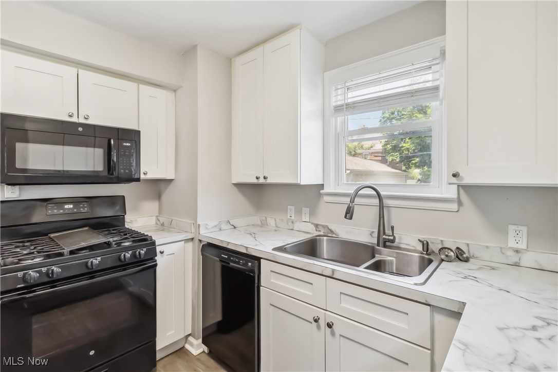13641 Cedar Road Cleveland, OH 44118 - Photo 11 of 42 Kitchen with black appliances, a sink, and white cabinets