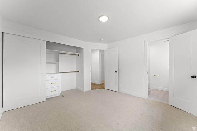 1898 West 600 South Provo, UT 84601 - Photo 20 of 32 Neutral-toned carpeting extends throughout this room, featuring a built-in closet system with sliding doors, adjustable shelving, and three drawers with gold-tone hardware