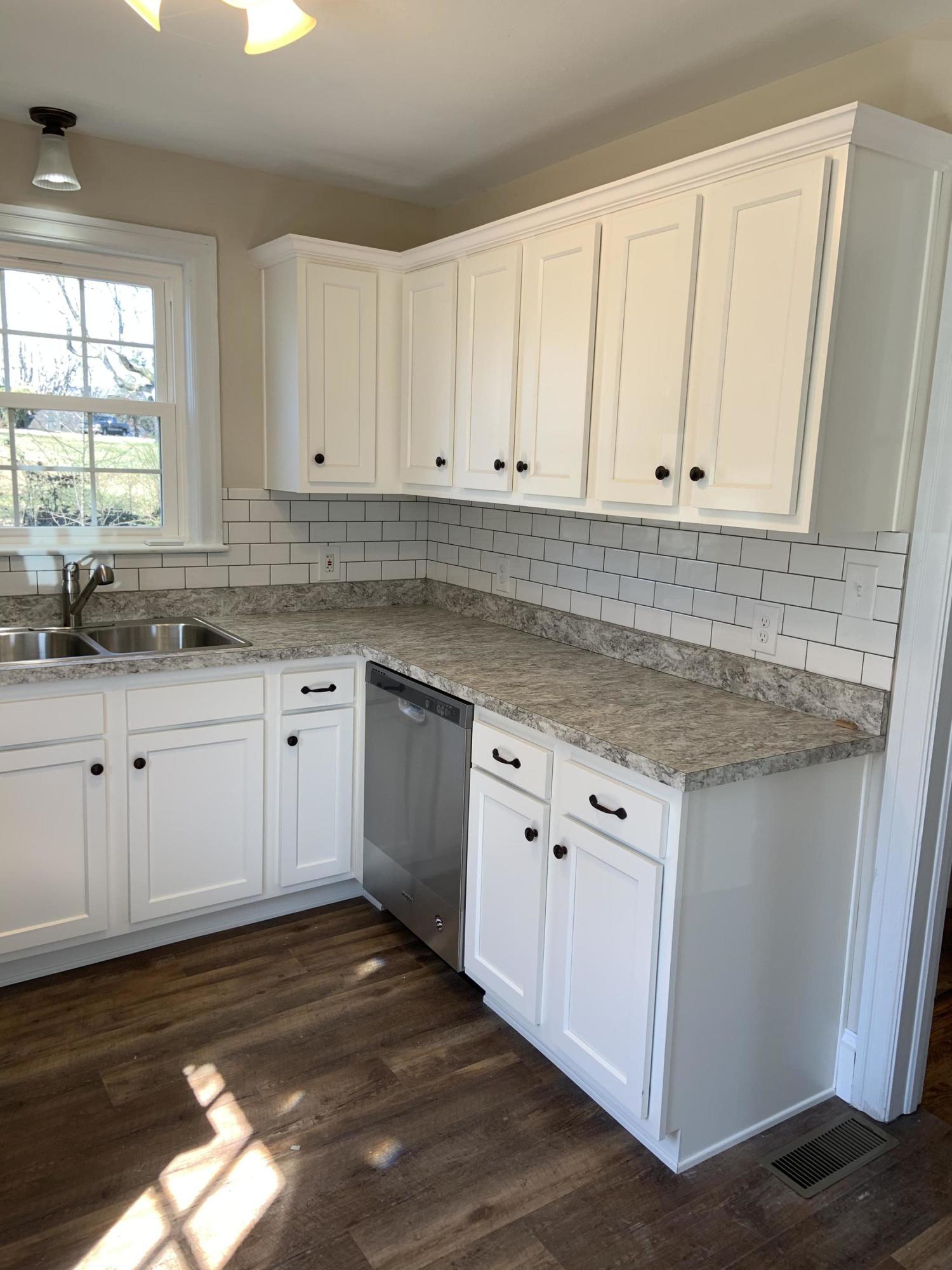 4004 Cove Road Roanoke, VA 24017 - Photo 12 of 30 a kitchen with granite countertop white cabinets white appliances a sink and a window