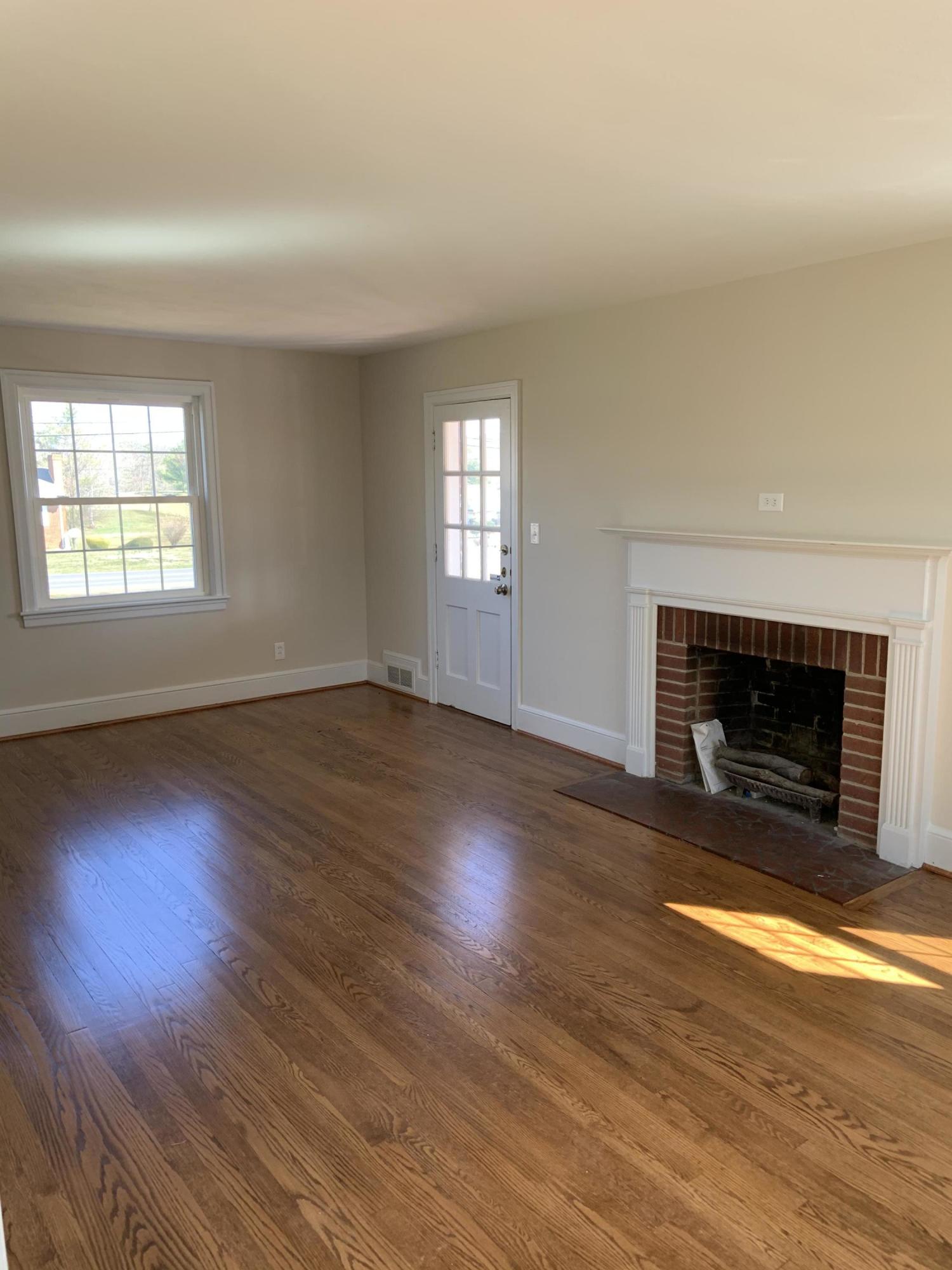4004 Cove Road Roanoke, VA 24017 - Photo 16 of 30 an empty room with wooden floor fireplace and windows