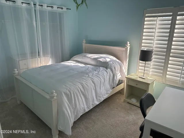 a bed sitting in a bedroom next to a window