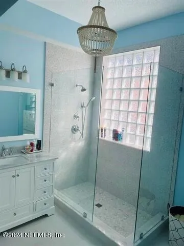 a bathroom with a shower a window and a sink
