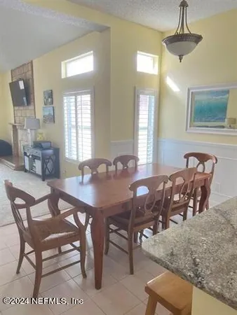 a view of a a dining room with furniture window and wooden floor