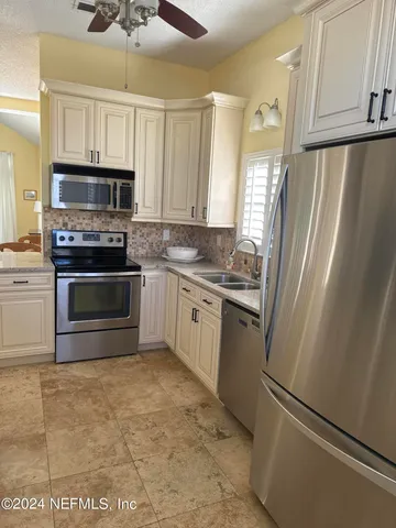 a kitchen with stainless steel appliances a stove a sink and a refrigerator