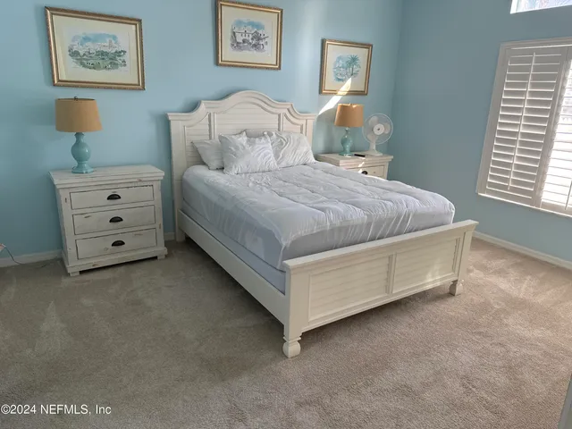 a spacious bedroom with a bed and a window