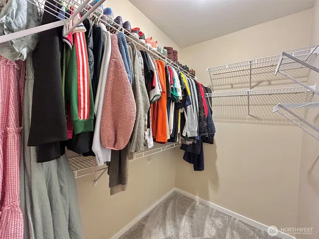 a view of walk in closet with clothes and shoes