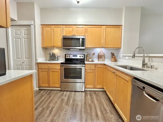 a kitchen with stainless steel appliances a stove sink and white cabinets