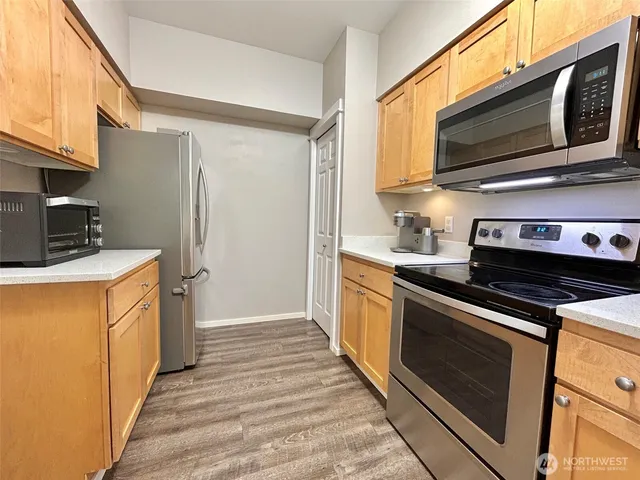 a kitchen with stainless steel appliances a stove a microwave oven cabinets and a sink