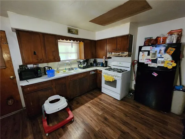 a kitchen with stainless steel appliances granite countertop a refrigerator sink stove and cabinets