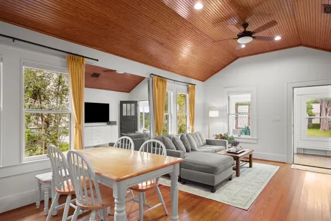 a dining room with furniture a flat screen tv and a large window