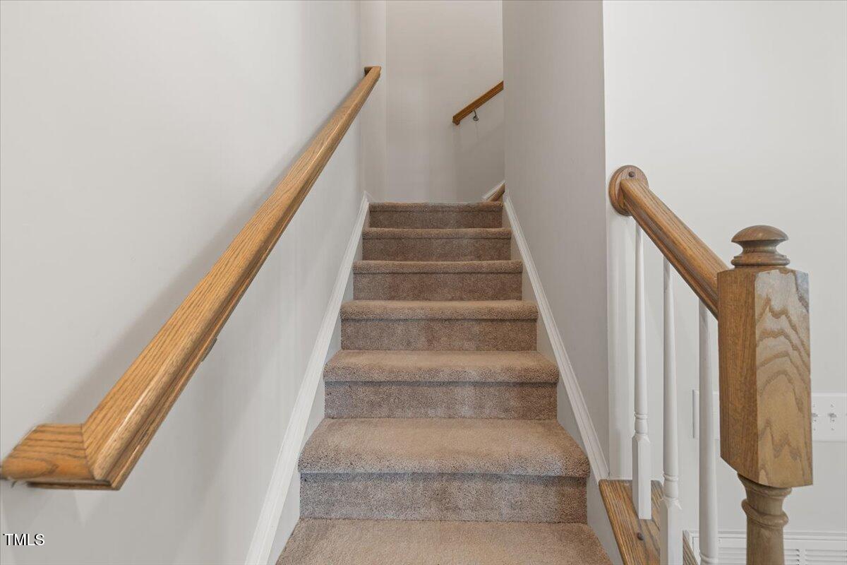 6620 Pathfinder Way Raleigh, NC 27616 - Photo 24 of 39 a view of staircase with white walls and railing