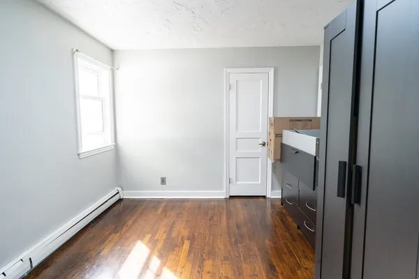 an empty room with wooden floor and a window