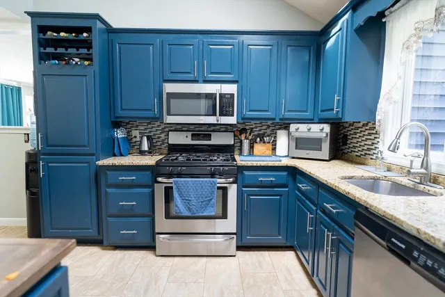 a kitchen with stainless steel appliances granite countertop wooden cabinets and a stove top oven