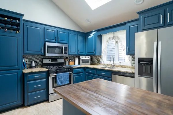 a kitchen with stainless steel appliances granite countertop a refrigerator stove microwave and sink