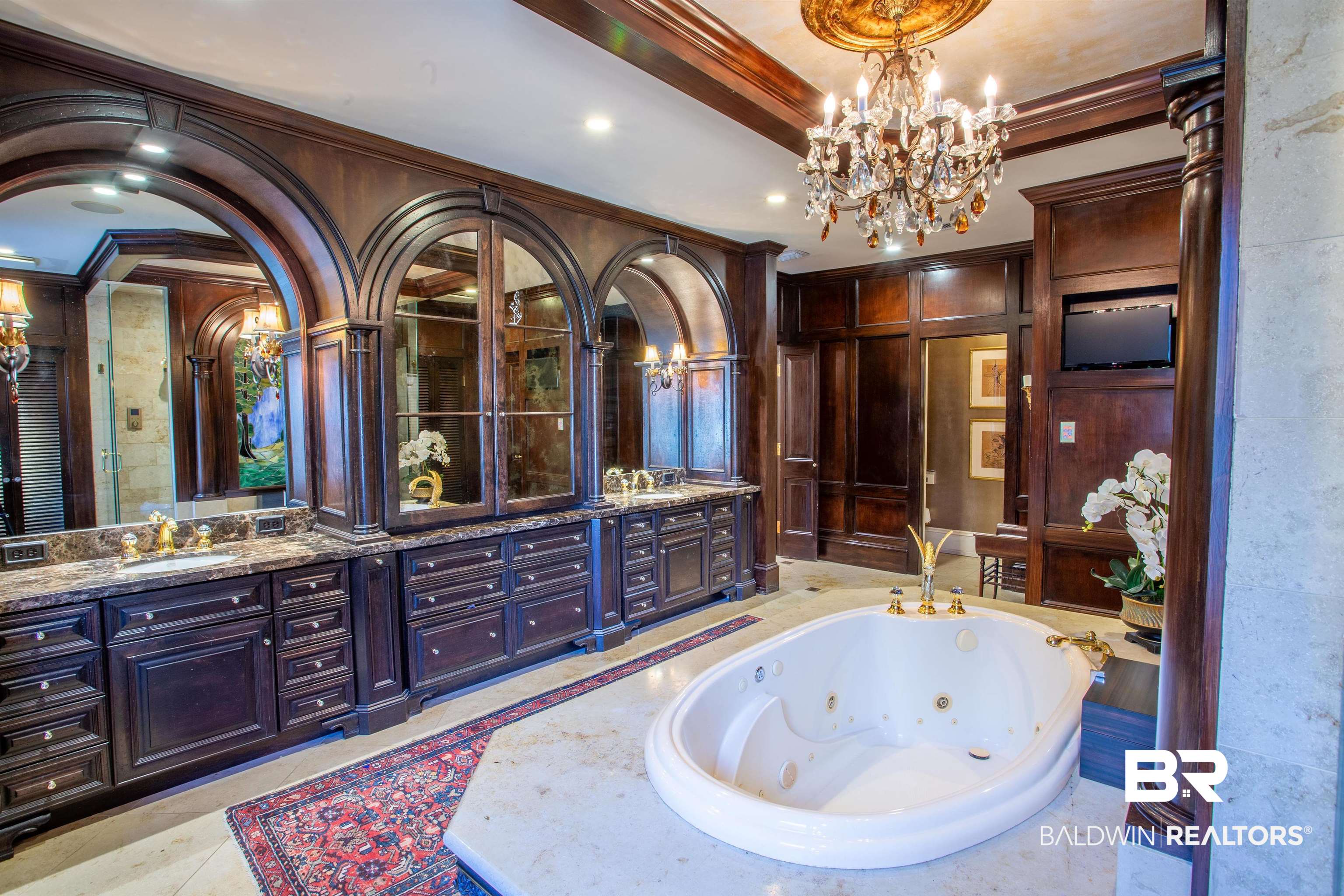 150 Austill Avenue Mobile, AL 36608 - Photo 28 of 39 Spacious bathroom featuring an oval jetted tub, dual vanity with stone countertops, dark wood cabinetry, and an ornate chandelier