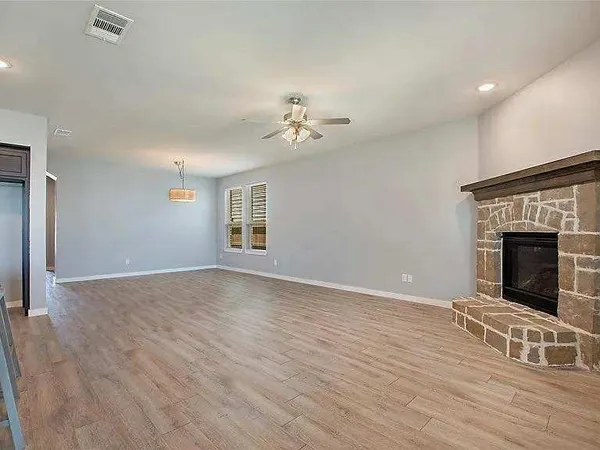 wooden floor fireplace and windows in an empty room