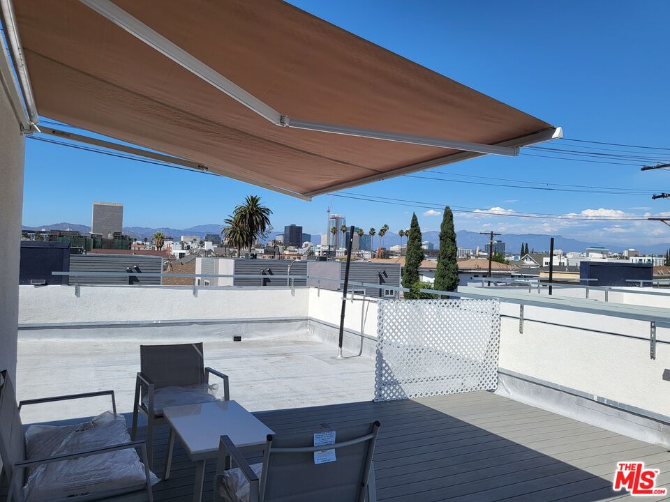 2754 West 12th Street Los Angeles, CA 90006 - Photo 14 of 17 a kitchen with stainless steel appliances kitchen island granite countertop a table chairs in it and wooden floors