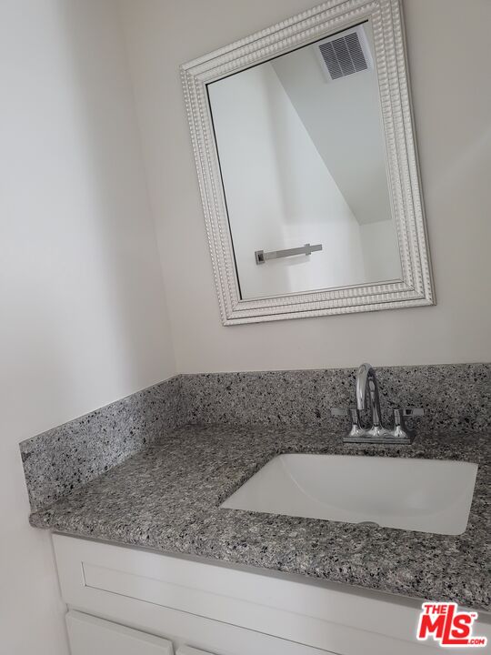 2754 West 12th Street Los Angeles, CA 90006 - Photo 4 of 17 a bathroom with a granite countertop sink and a mirror
