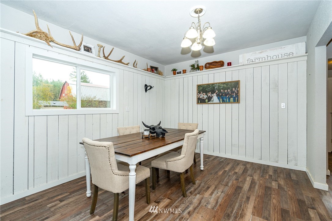 443 Tucker Road Toledo, WA 98591 - Photo 10 of 39 a dining room with wooden floor a chandelier a wooden table and chairs