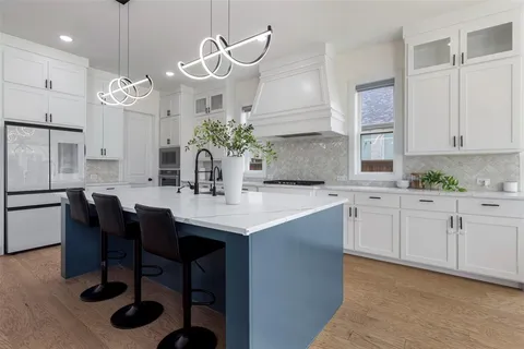 a kitchen with granite countertop a sink cabinets and stainless steel appliances