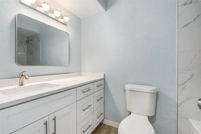 a bathroom with a toilet a sink and mirror