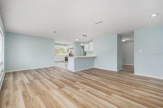 a view of a kitchen with wooden floor and kitchen appliances