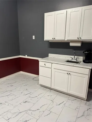 a kitchen with granite countertop white cabinets and sink