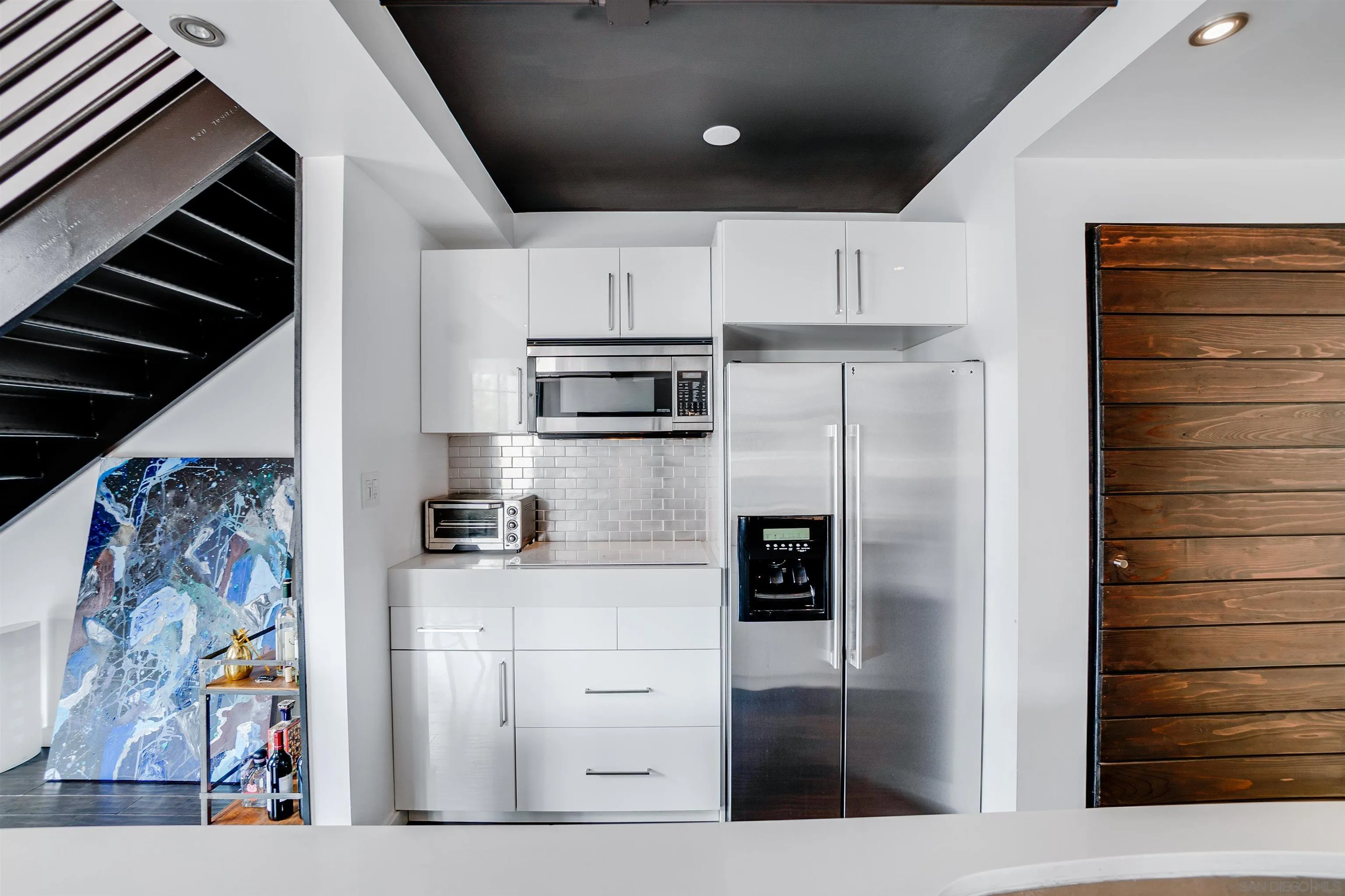 702 Ash Street, Unit 102 San Diego, CA 92101 - Photo 11 of 31 a kitchen with stainless steel appliances kitchen island granite countertop a refrigerator and a stove
