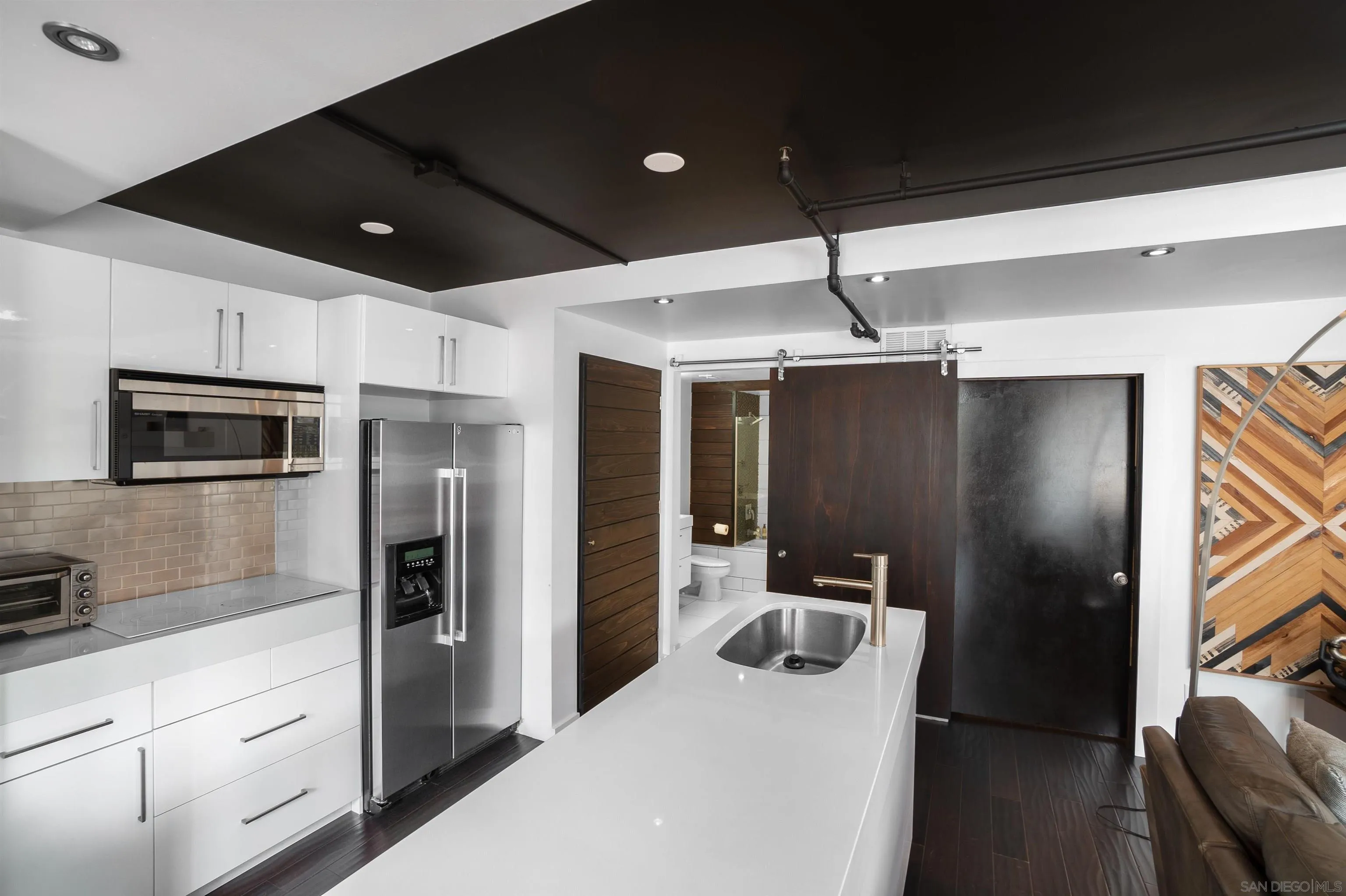 702 Ash Street, Unit 102 San Diego, CA 92101 - Photo 12 of 31 a kitchen with stainless steel appliances granite countertop a refrigerator and a sink